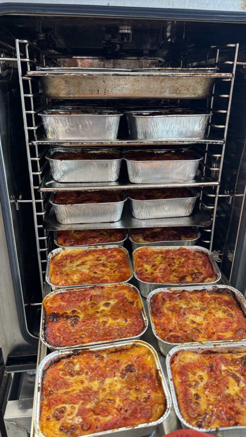 Monoportions of lasagne being cooked for an event