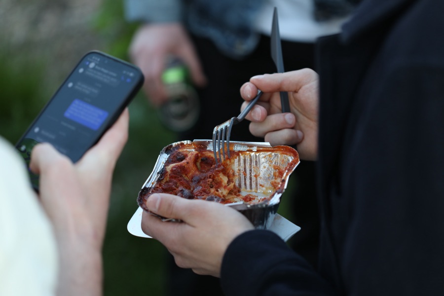 Guest eating a portion of lasagne at an event